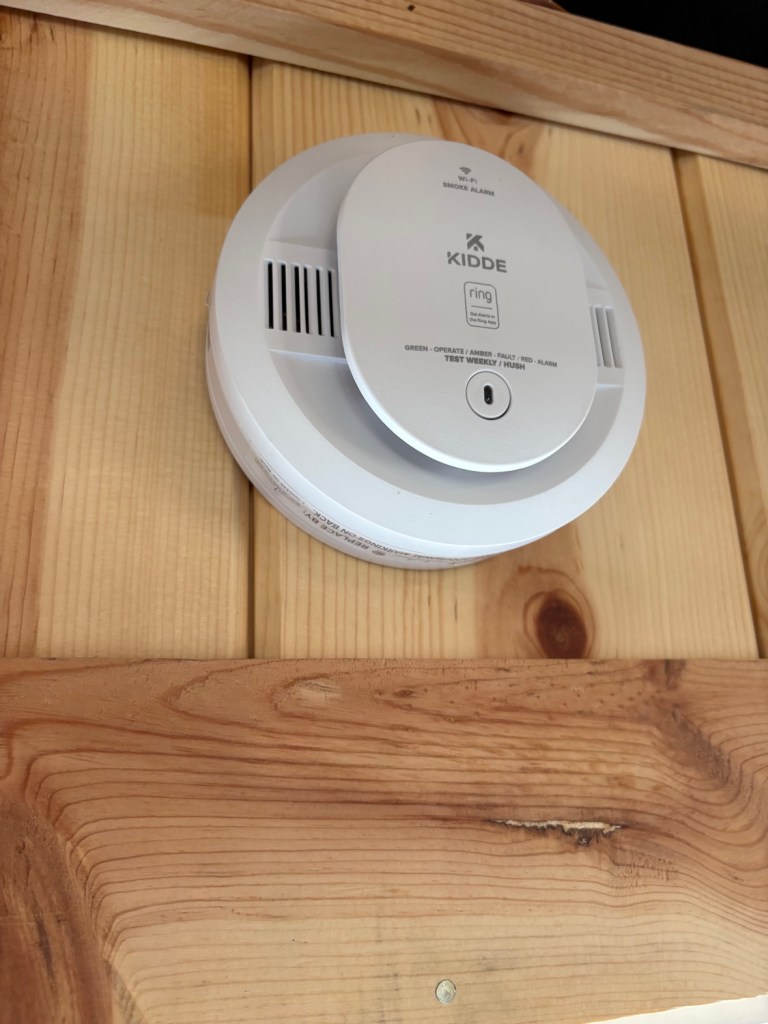 Kidde smart smoke detector mounted on the gym ceiling
