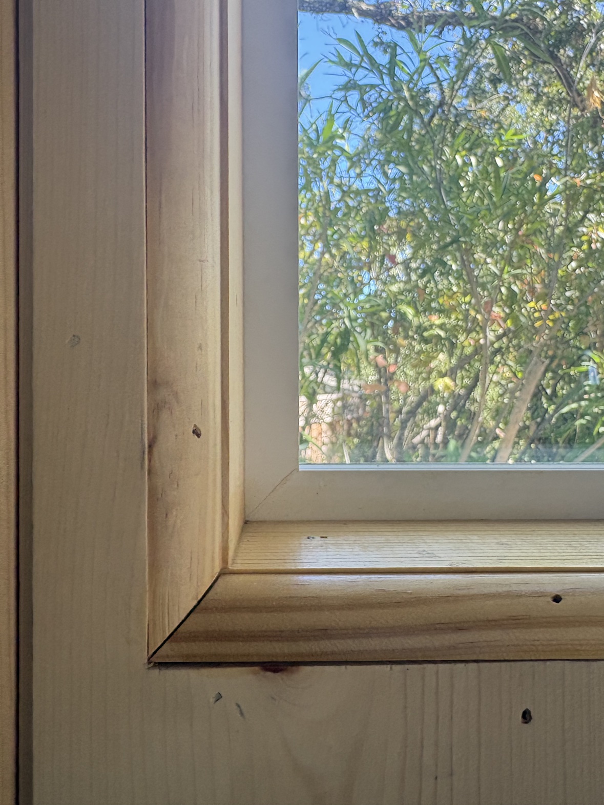 Close-up of a mitered trim joint at the corner of a shed window sill